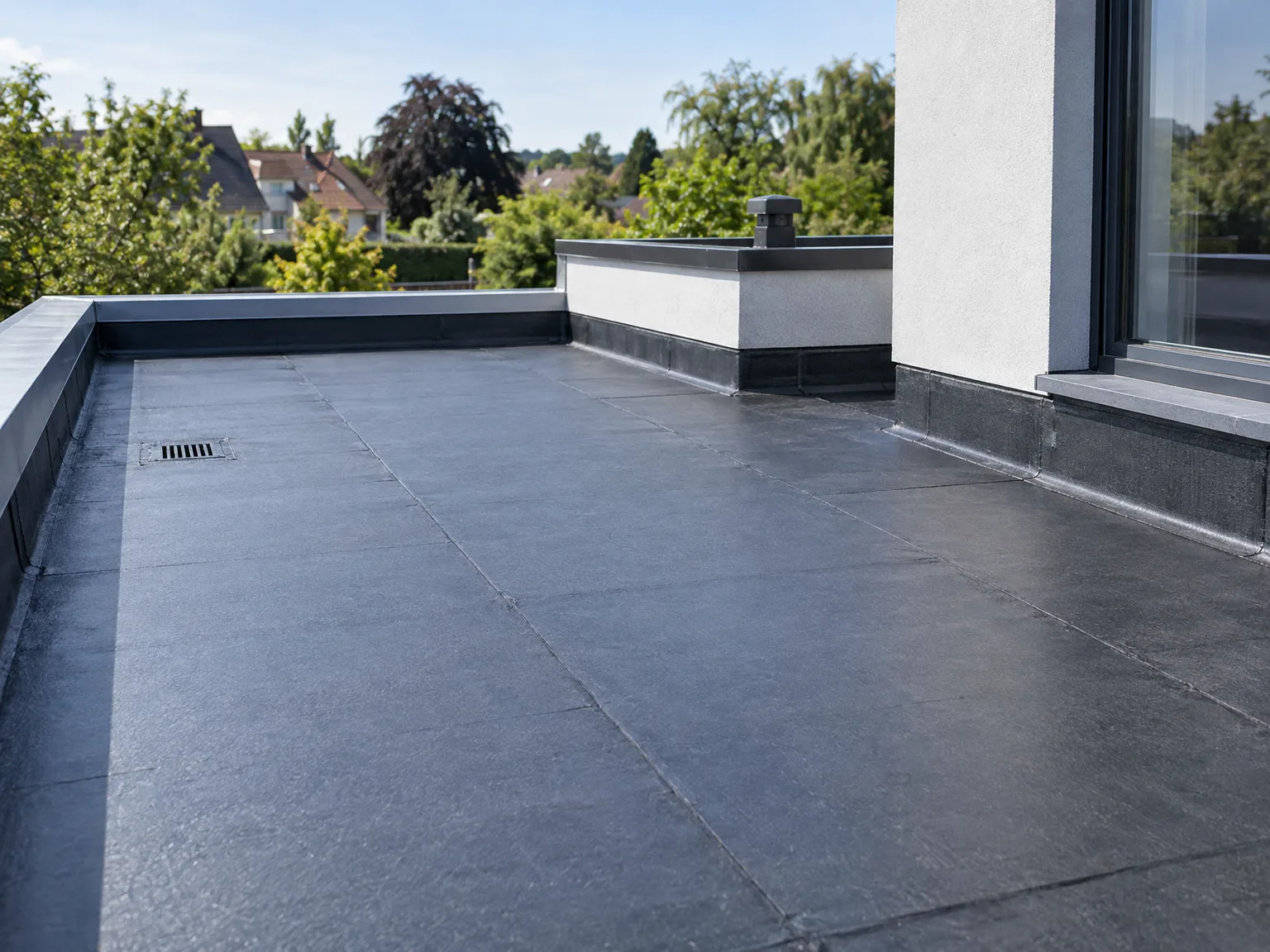 Étanchéité d'un toit plat avec couverture bitumineuse noire et système de drainage fonctionnel