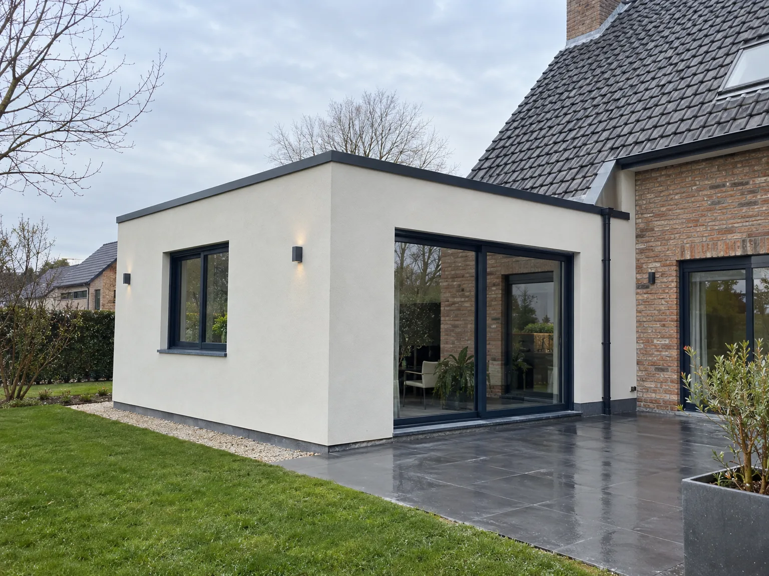 Extension de maison moderne en crépi blanc avec grandes baies vitrées et terrasse