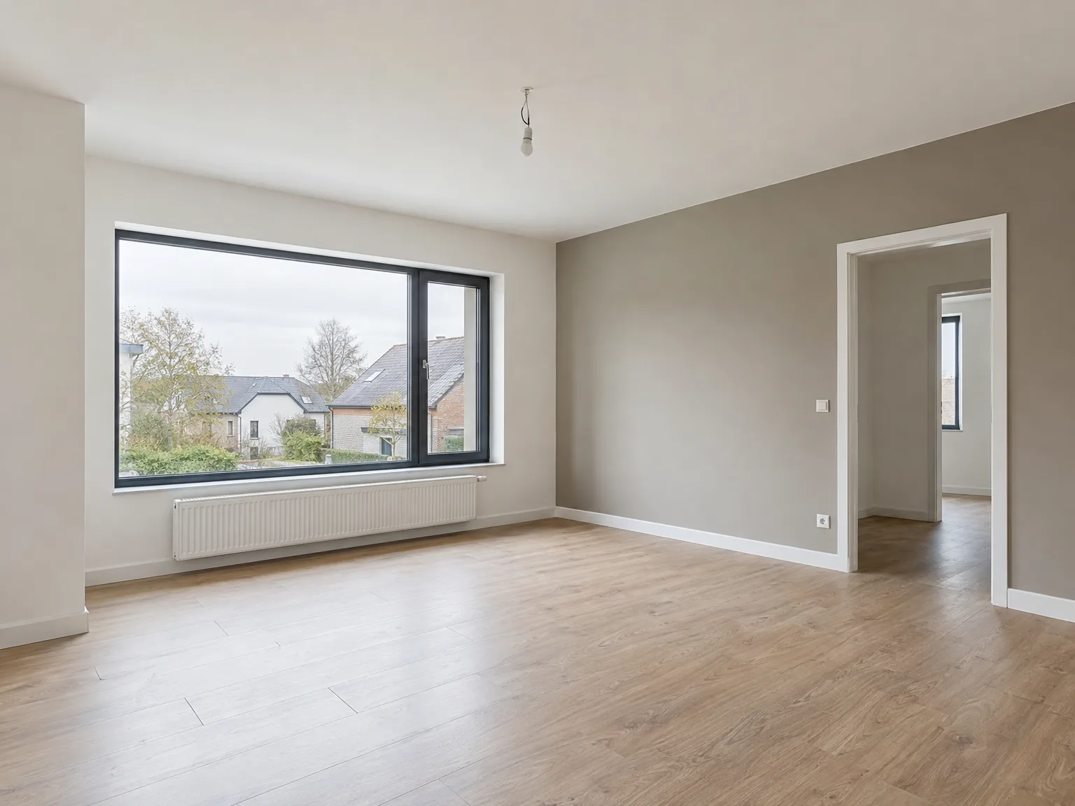 Rénovation d'appartement : pièce repeinte en gris beige, parquet neuf et fenêtres design