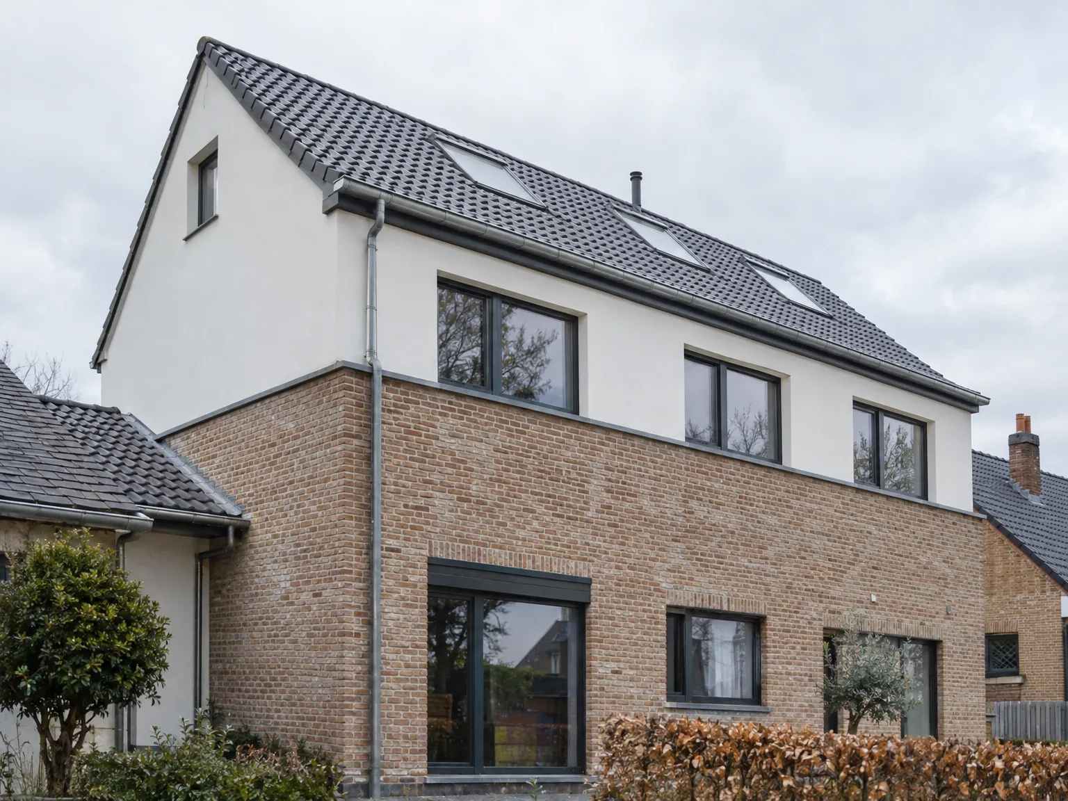 Maison avec couverture ardoise noire, gouttières zinc et façade en briques